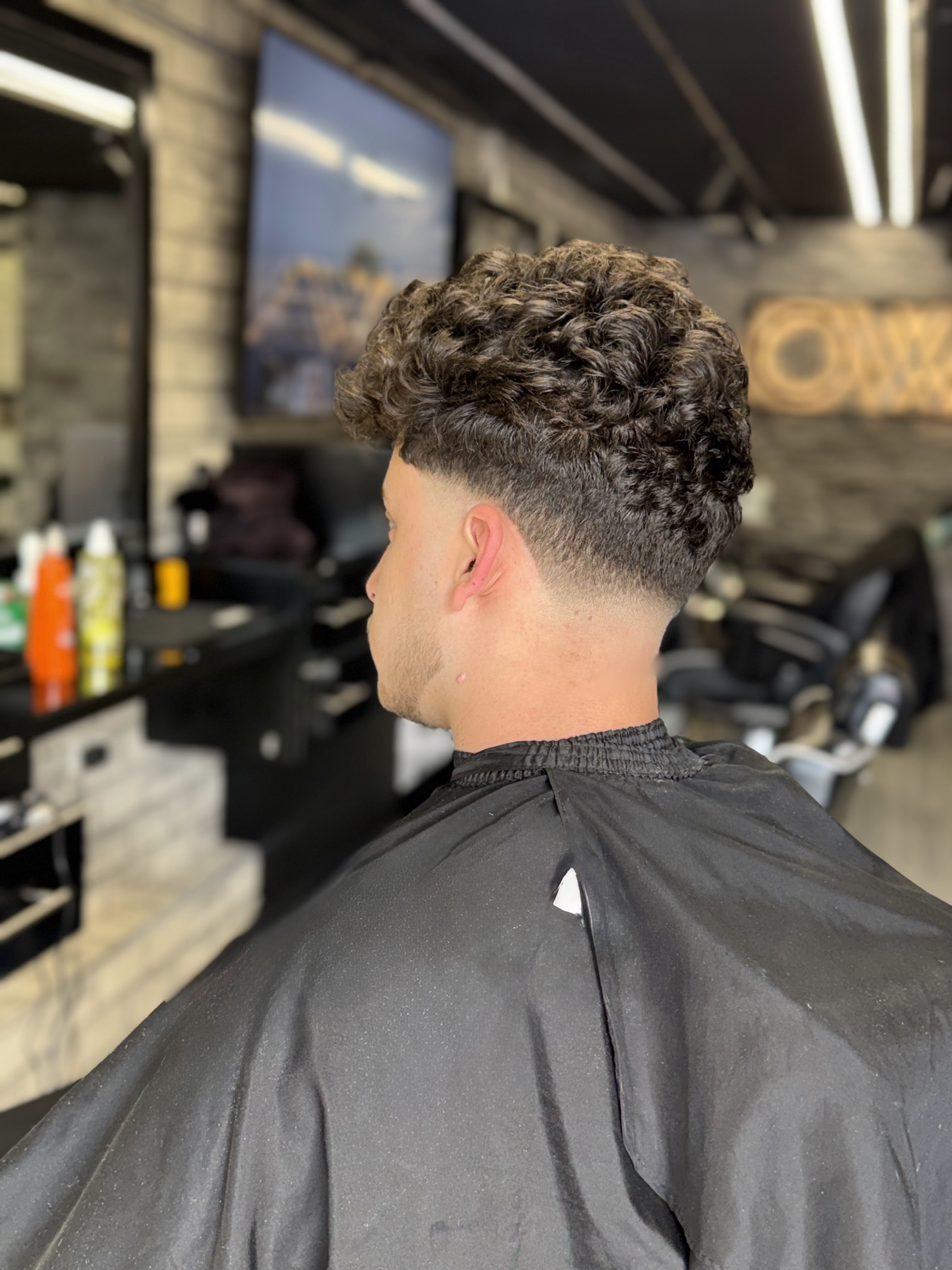 Finished curly fade result, viewed from behind