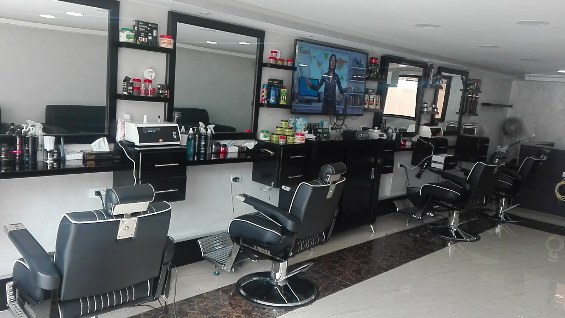 Row of styling stations with mirrors and barber chairs