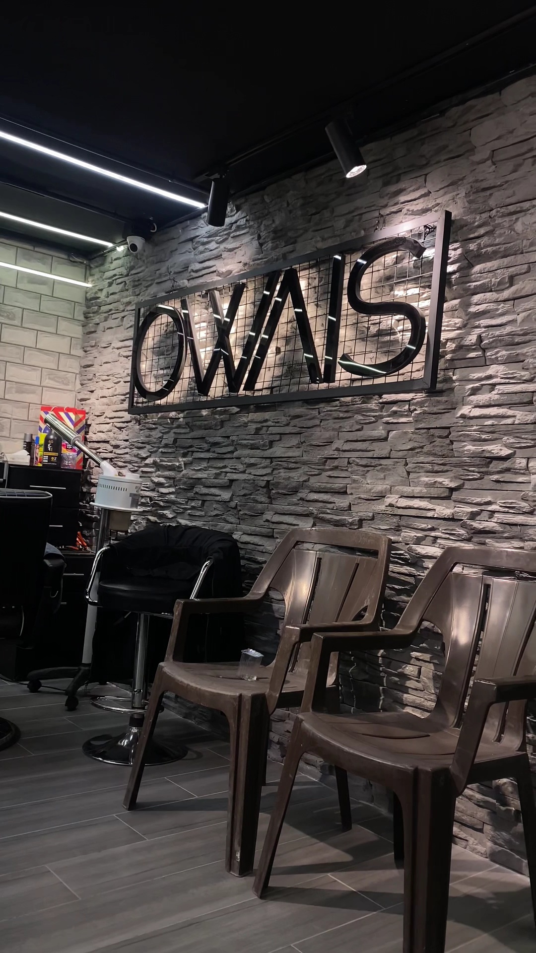 OWAIS wire-mesh sign on a stacked-stone feature wall